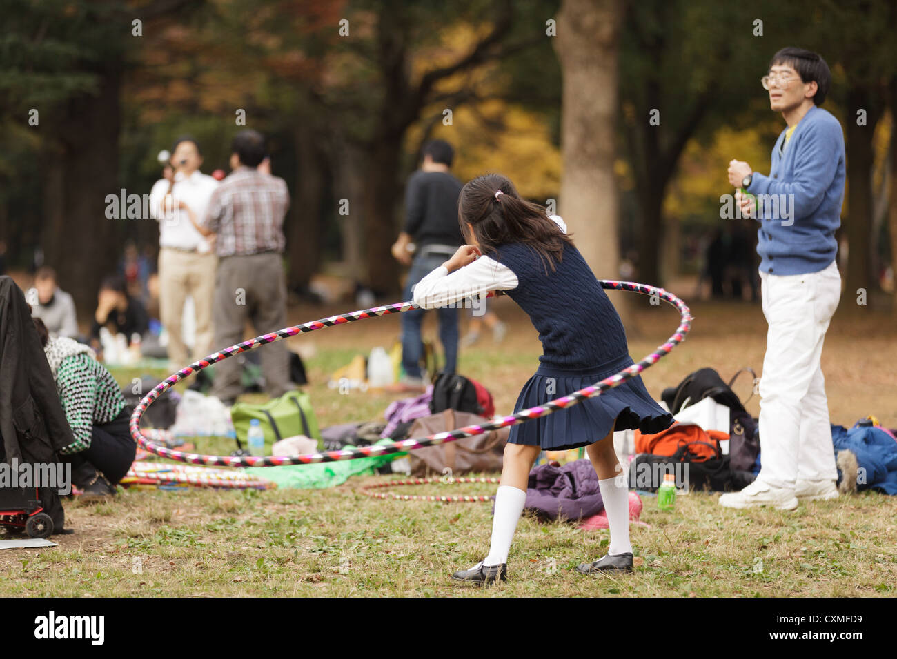 Little japanese girl playing with large  hoola hoop in Harajuku park, Tokyo, Japan Stock Photo