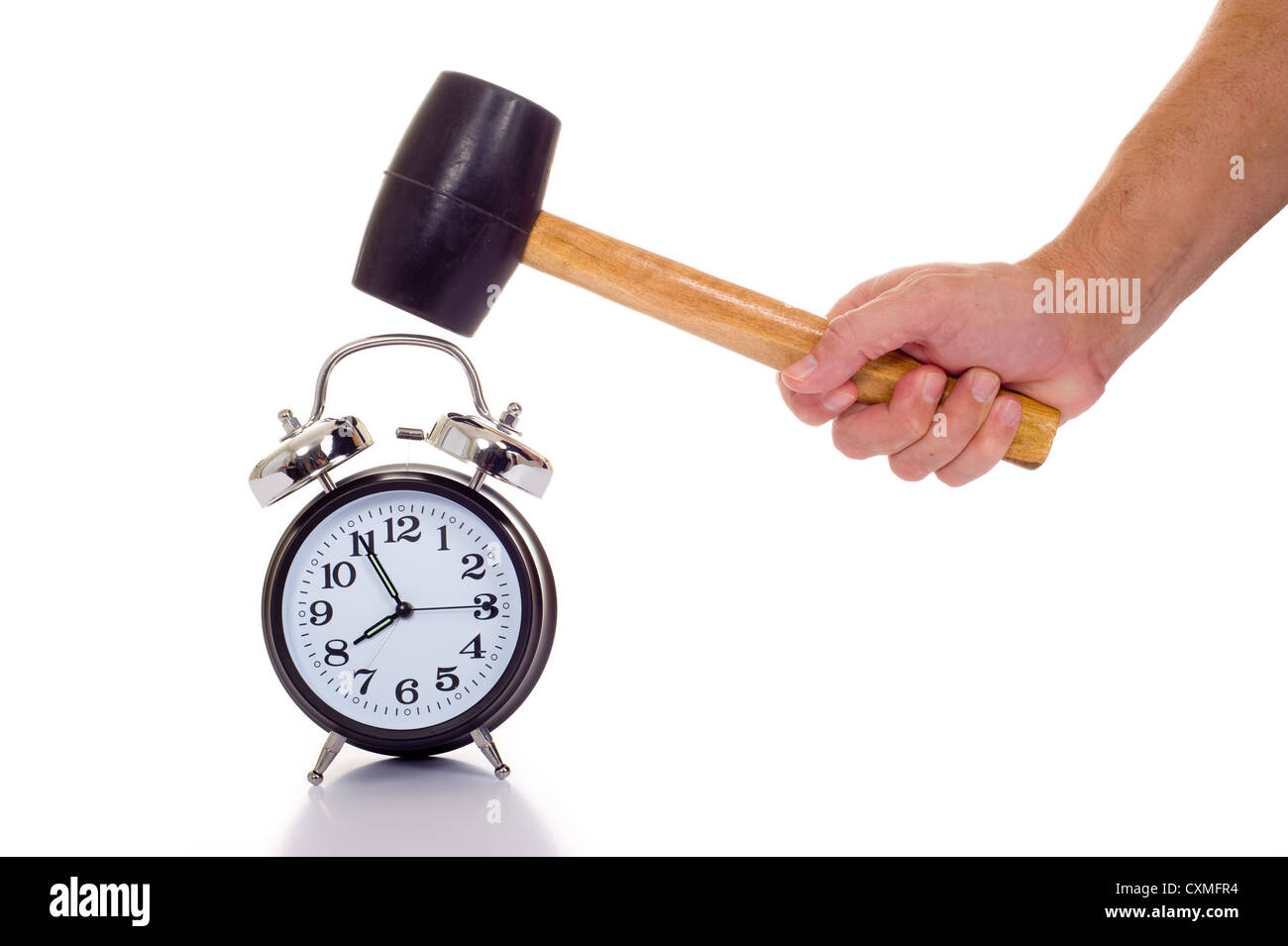 a hand holding a black mallet or hammer about to crush an old fashioned alarm clock on a white background, time concept Stock Photo