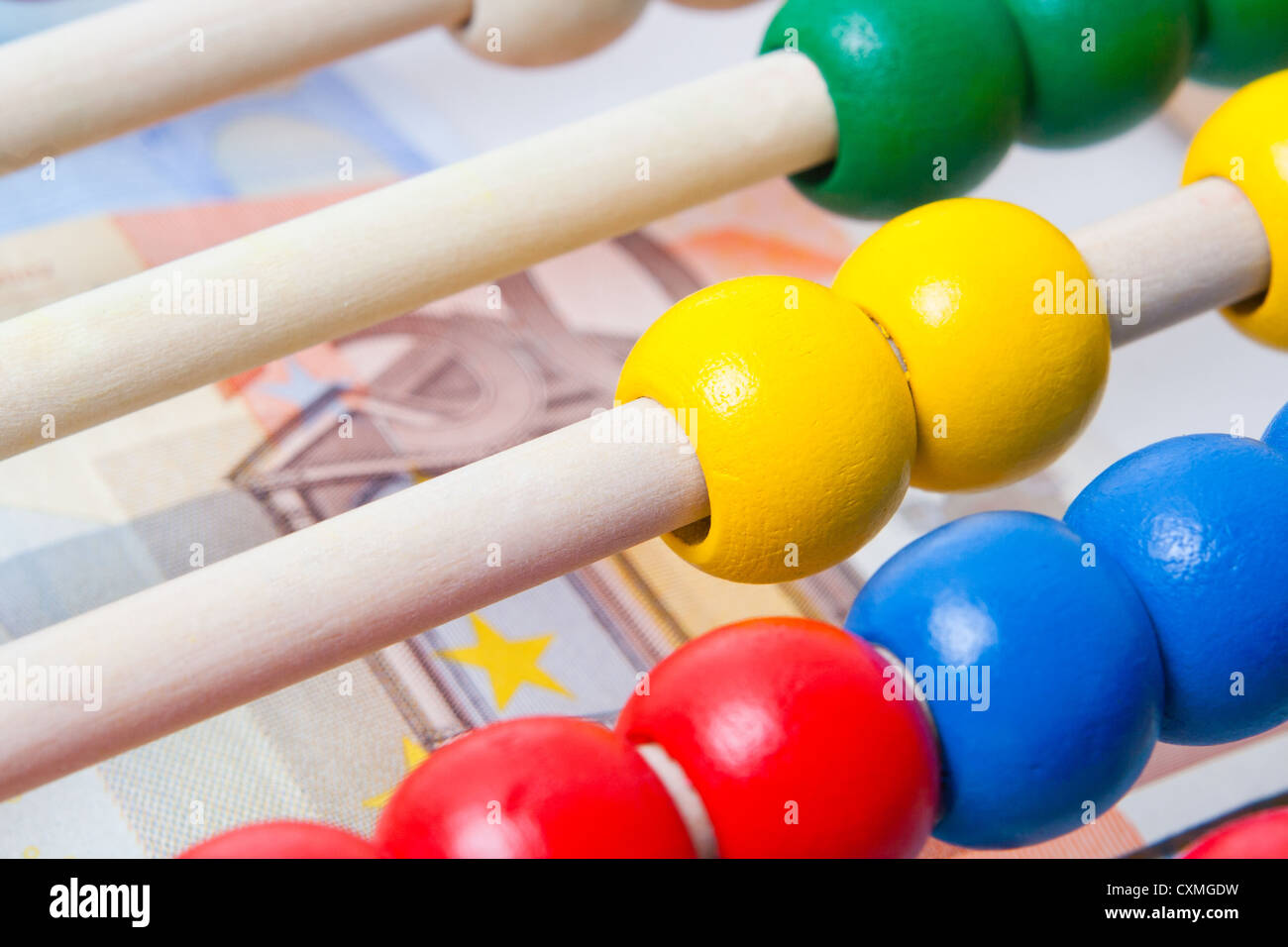 Education concept - Abacus with many colorful beads and banknotes in background Stock Photo