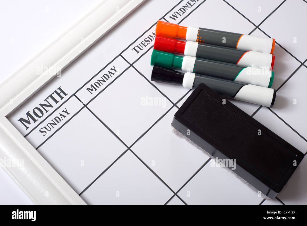 Blank white calendar with dry erase markers and an eraser Stock Photo Blank white calendar with dry erase markers and an eraser Stock Photo