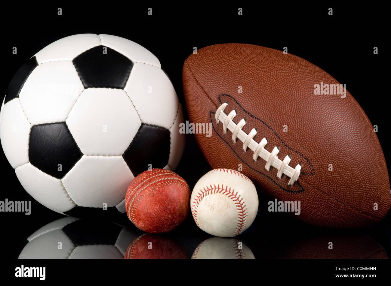 Assorted sports balls including a soccer ball, American football, baseball and cricket ball as a background Stock Photo