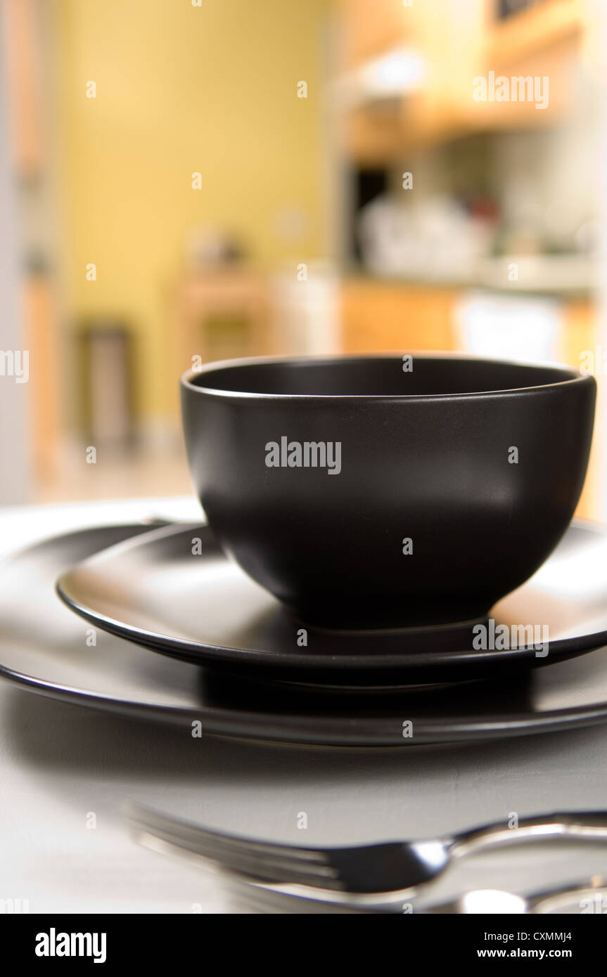 Dinnerware setting with black plates and flatware Stock Photo Alamy