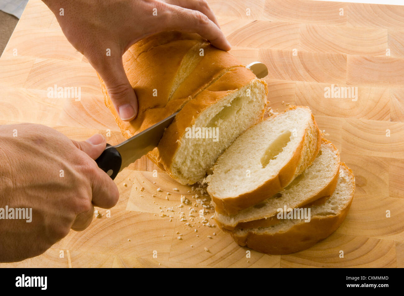 slicing bread on wood cutting board with a bread knife Stock Photo Alamy