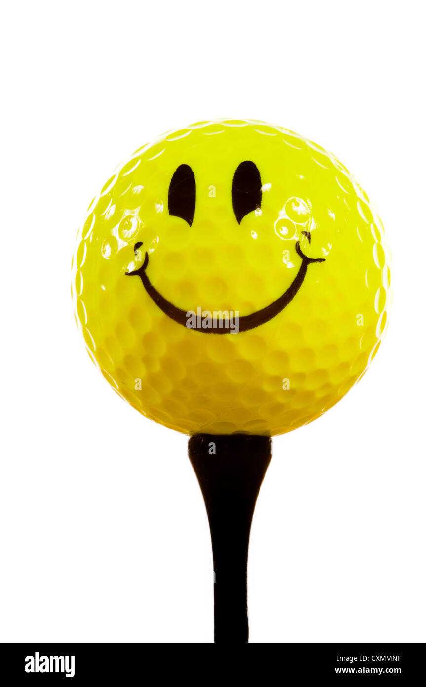 Golf tee and a yellow smiley face golf ball on a white background Stock Photo