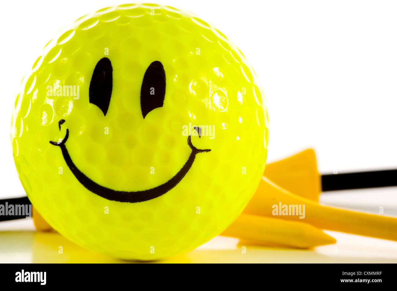 Golf tee and a yellow smiley face golf ball on a white background Stock Photo