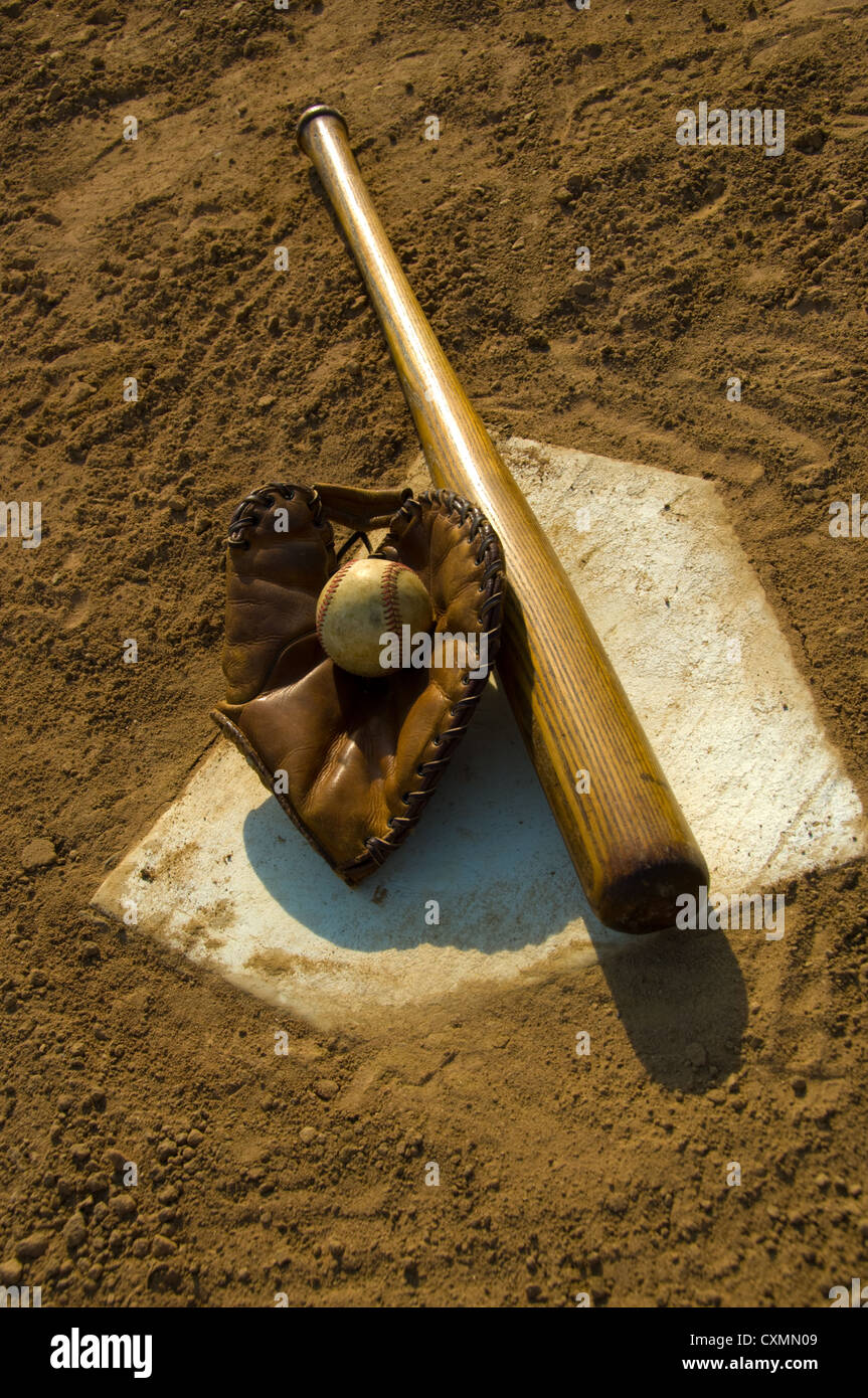 Vintage wooden baseball bat, glove and baseball on home plate Stock