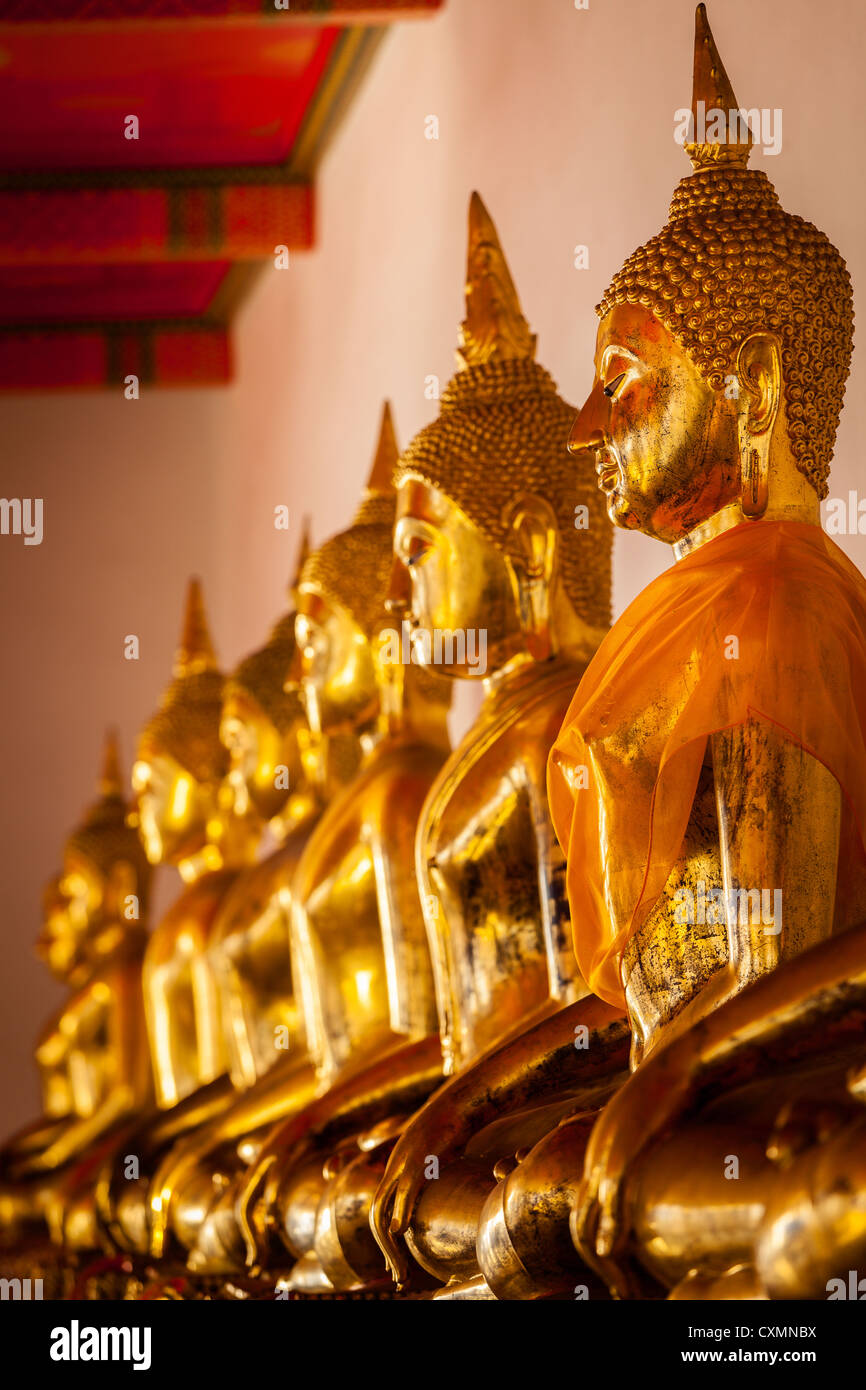Row Of Sitting Buddha Statues In Buddhist Temple Thailand Stock Photo row-of-sitting-buddha-statues-in-buddhist-temple-thailand-stock-photo