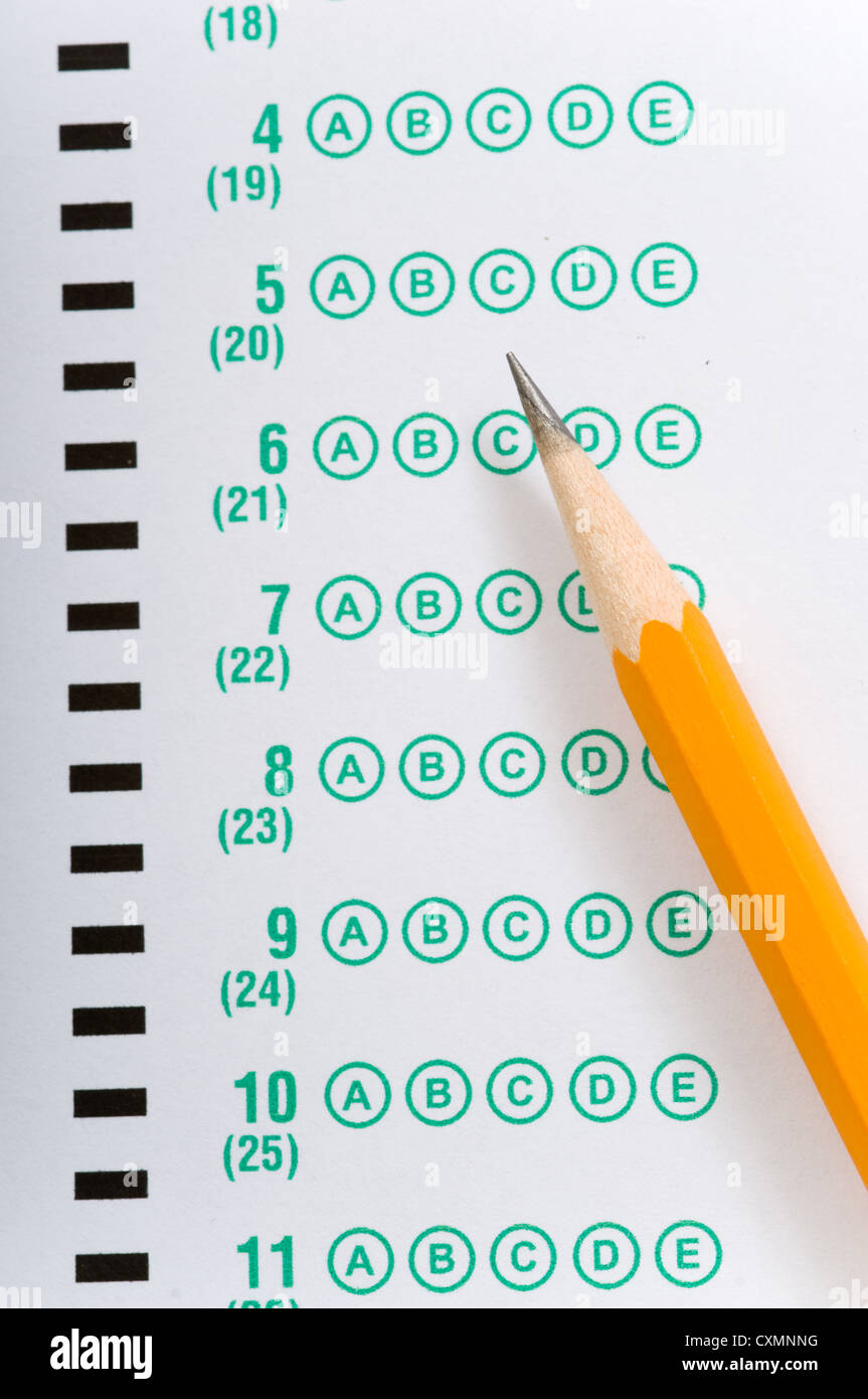 a yellow pencil lying on a multiple choice test or exam answer sheet Stock Photo