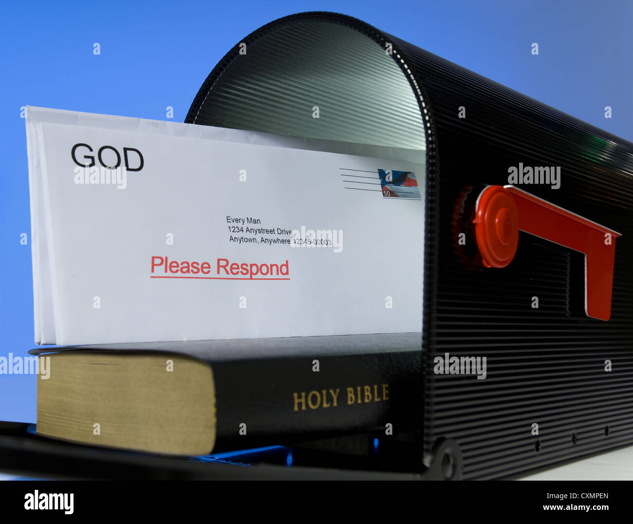 Mail box containing Holy Bible on white background, symbolizing that the Bible is a message or mail from God Stock Photo