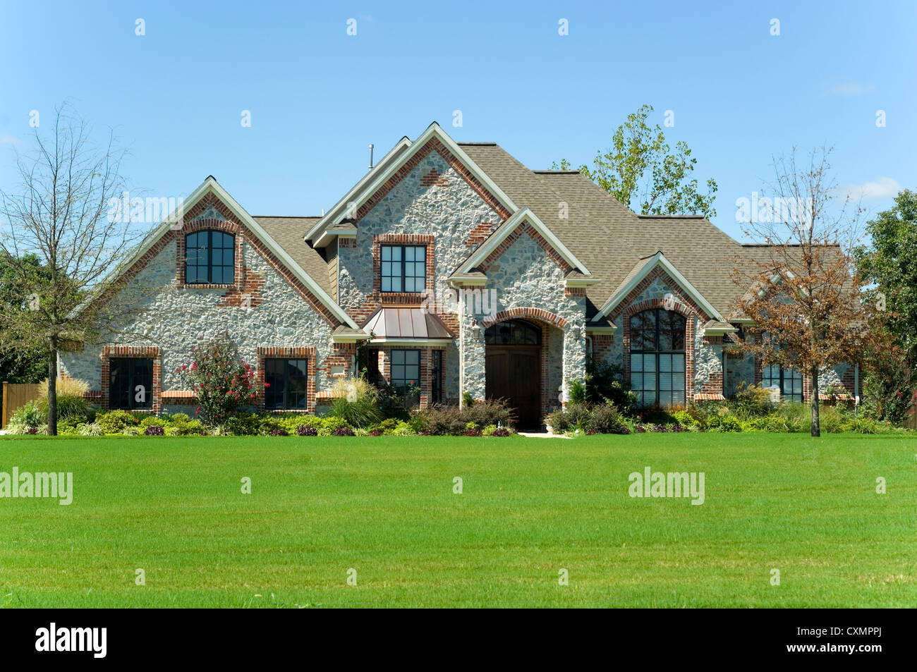 Beautiful two story home, real estate or property with landscaped lawn against a blue sky