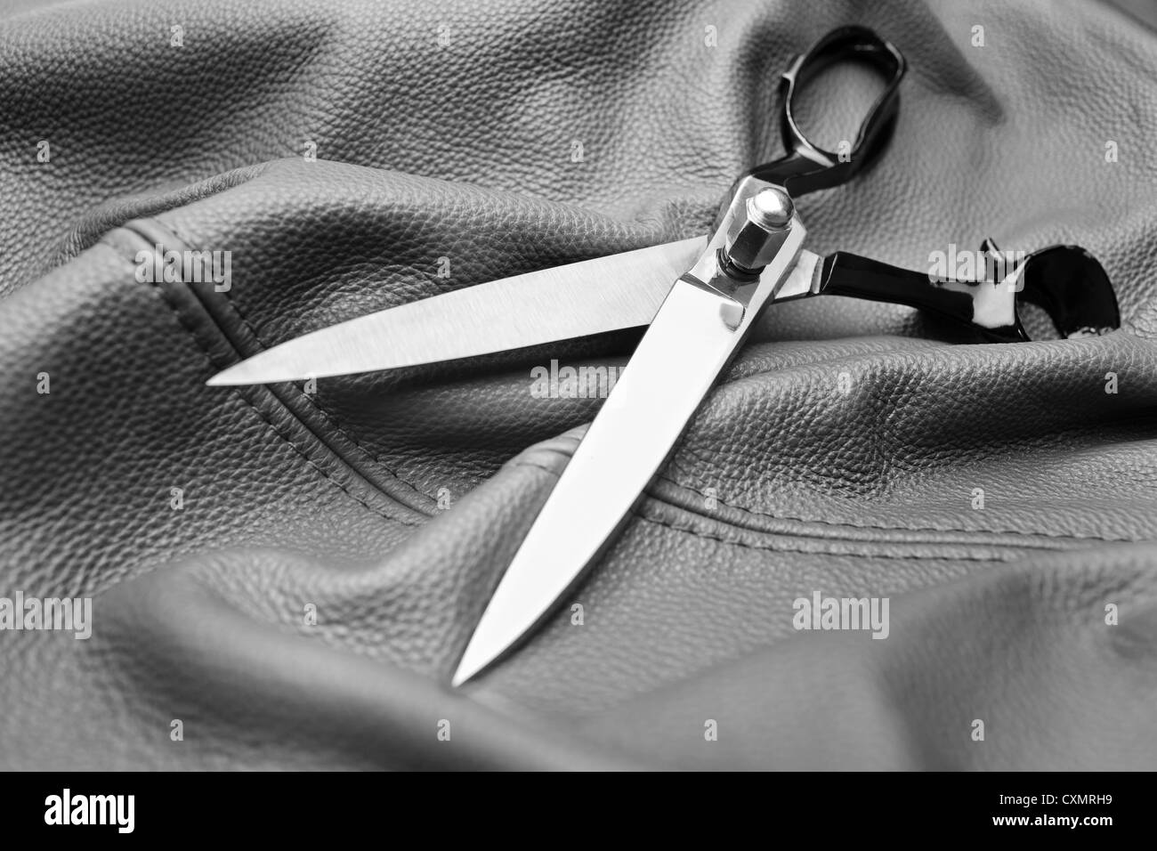 A scissors on a black leather background Stock Photo