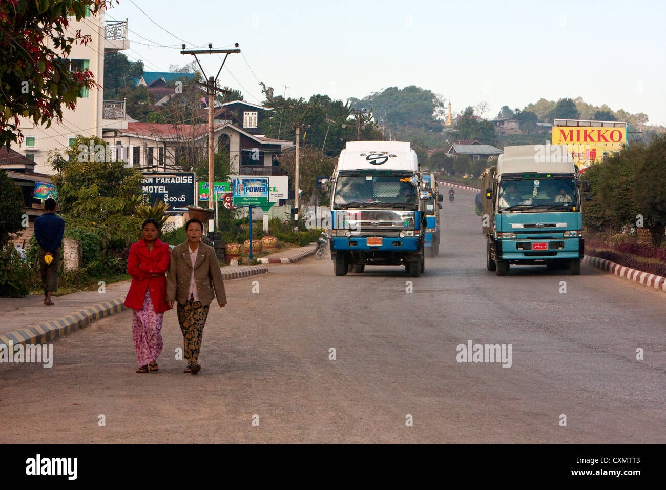 Myanmar, Burma, Kalaw. Vehicular Traffic on a Main Street through Kalaw, Women Walking. Stock Photo