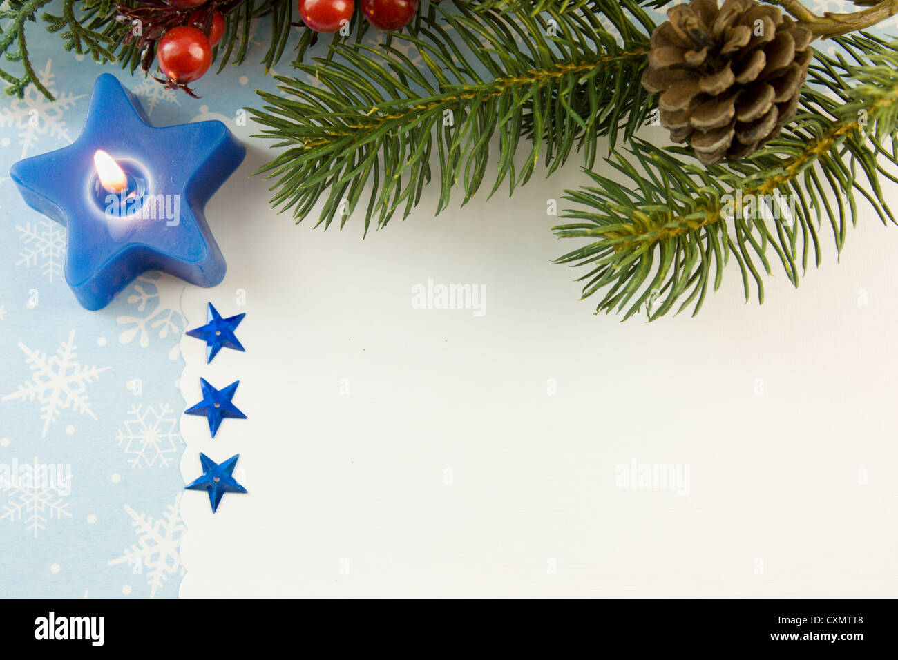blank Christmas card with blue star candle, fir branch and copyspace Stock Photo