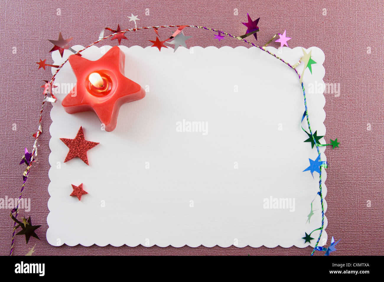 blank Christmas card with red candle, star tinsel, and copyspace Stock Photo
