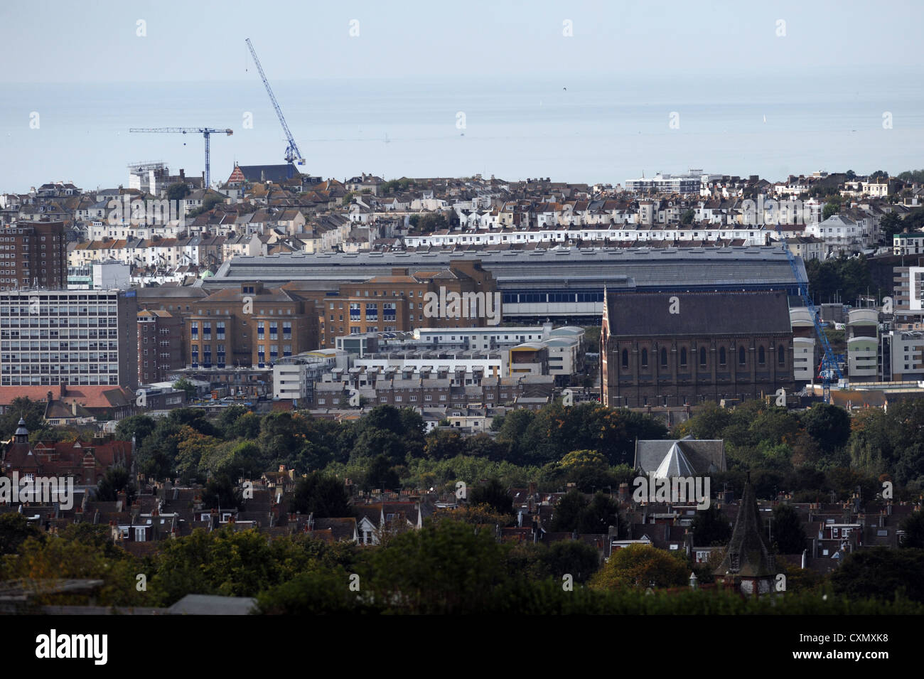 View from near Brighton racecourse looking across city rooftops showing St Bartholomews Church to the right and the station UK Stock Photo