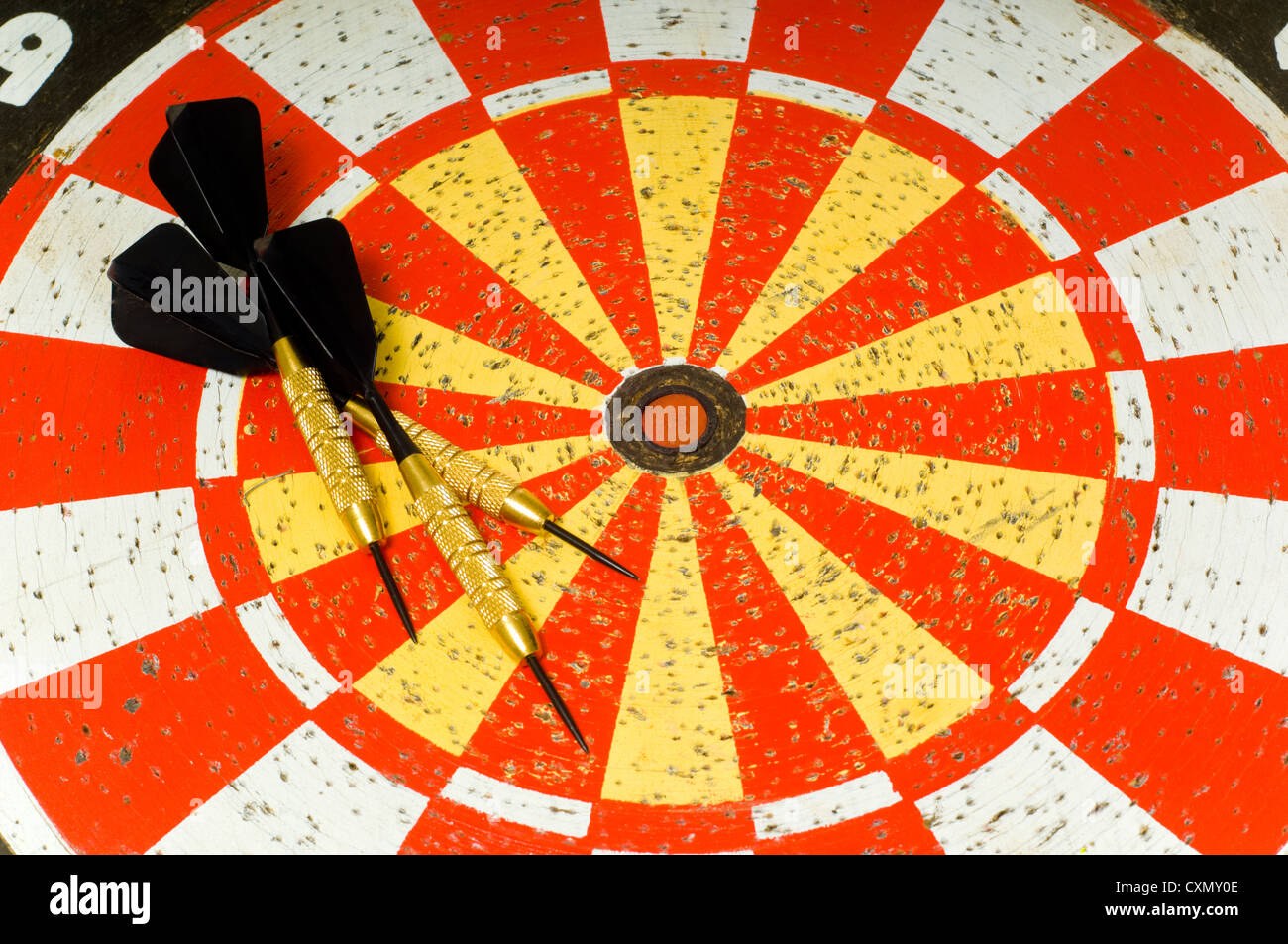 Dartboard with several darts lying on top of board Stock Photo