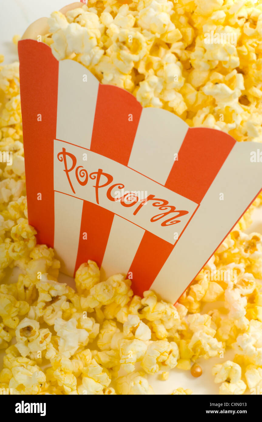 Movie popcorn on white background with red striped box and freshly popped popcorn Stock Photo