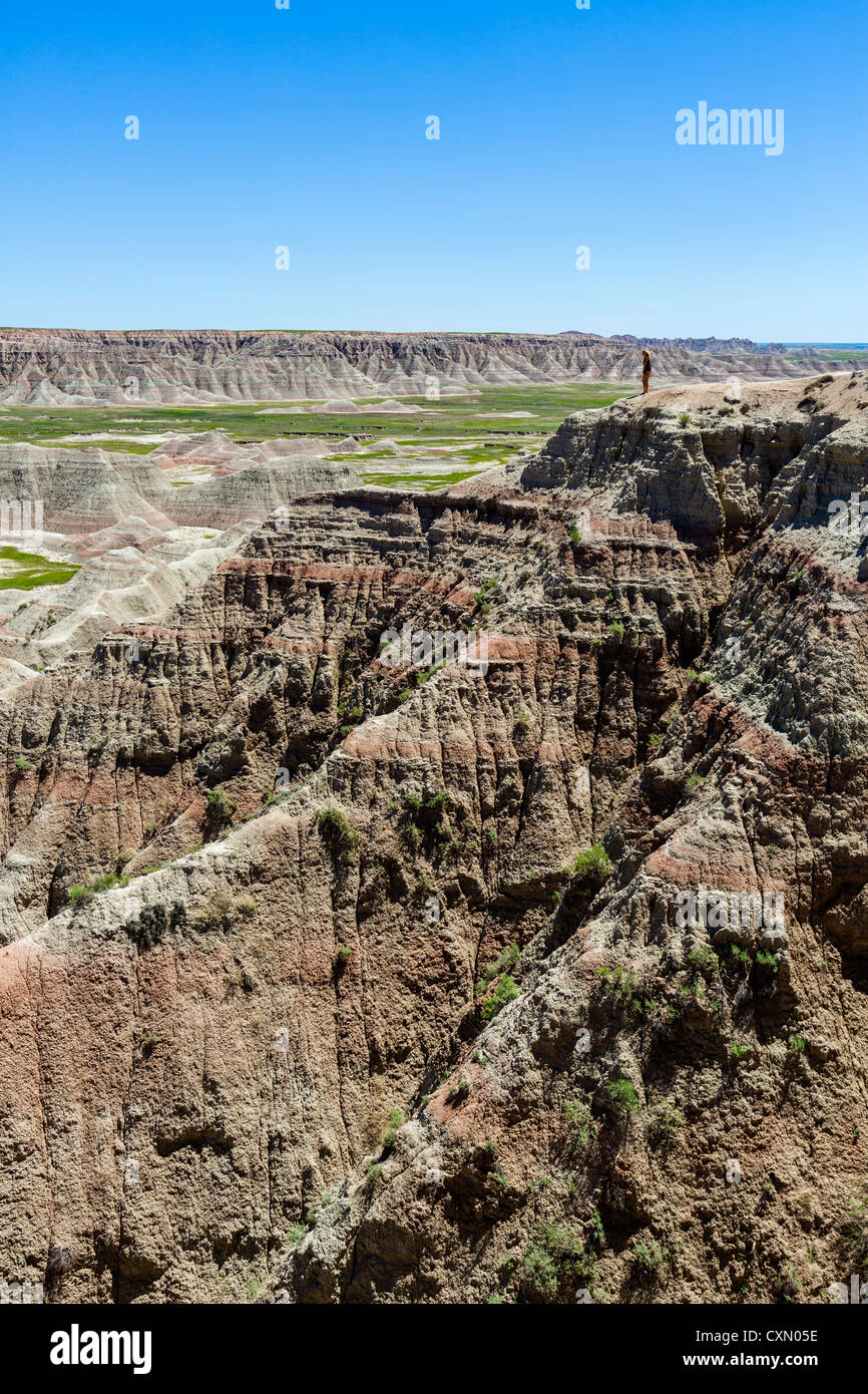 Grl standing on the edge of a cliff at the Big Badlands Overlook, Badlands National Park, South Dakota, USA Stock Photo