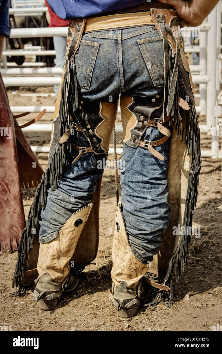 A cowboy in leather chaps and boots waits for his turn to ride at a rodeo  Stock Photo - Alamy