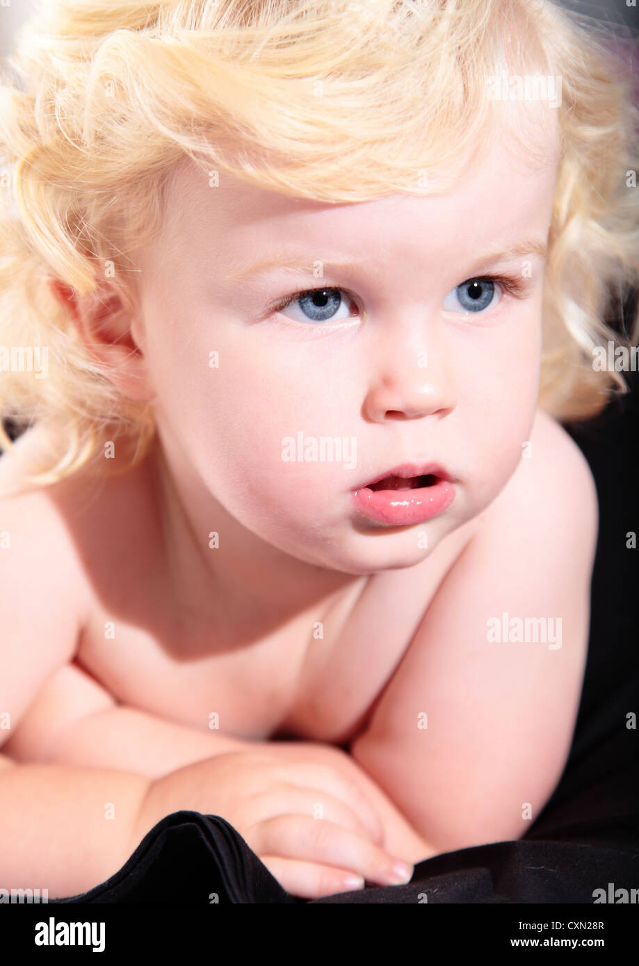 Cute Baby Boy With Curly Blond Hair And Blue Eyes Stock Photo