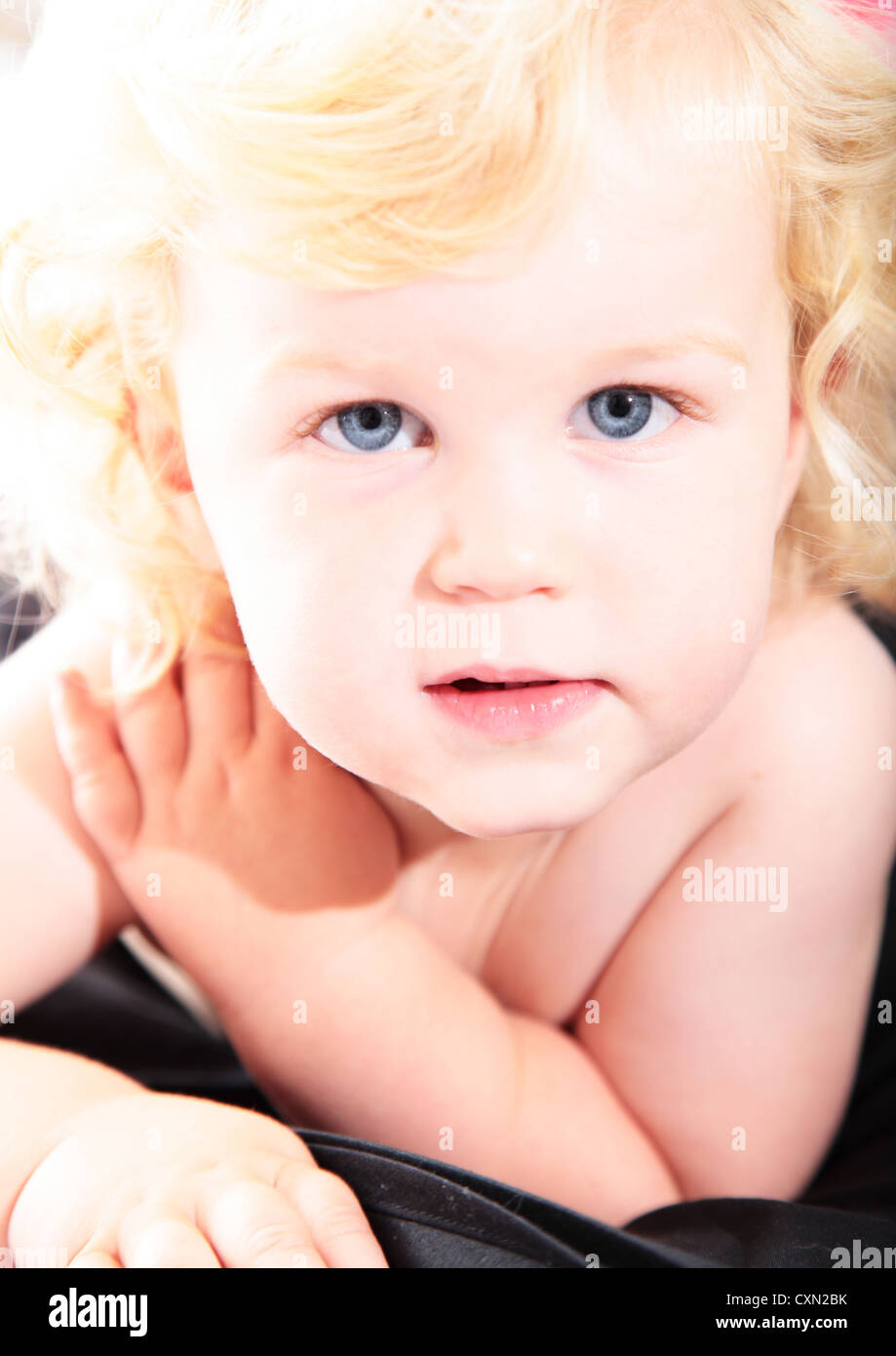 Cute Baby Boy With Curly Blond Hair And Blue Eyes Stock Photo