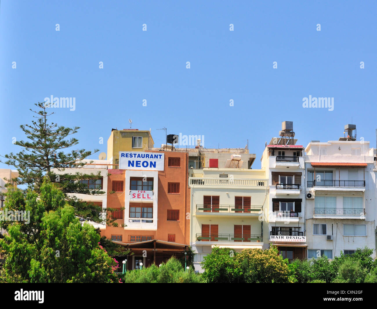 Misspelt 'For Sale' sign on building  around Agios Nikolaos Lake: Agios Nikolaos, Crete , Greece Stock Photo