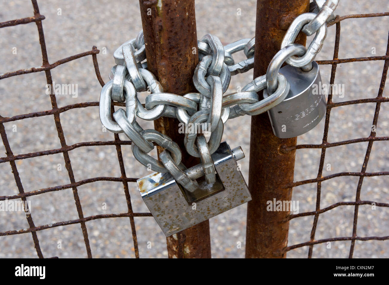 Rusty metal gates locked with padlocks and heavy chain Stock Photo