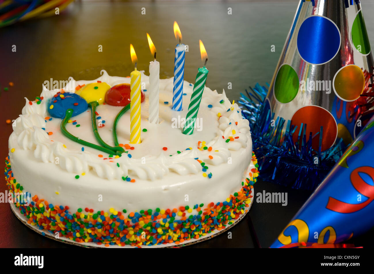 Decorated Birthday cake with candles and party hats Stock Photo Alamy
