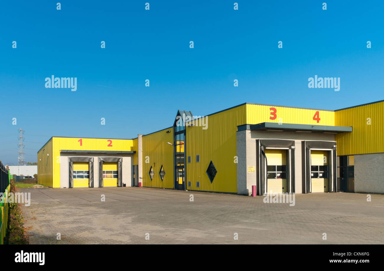 yellow industrial warehouse with numbered loading docks Stock Photo