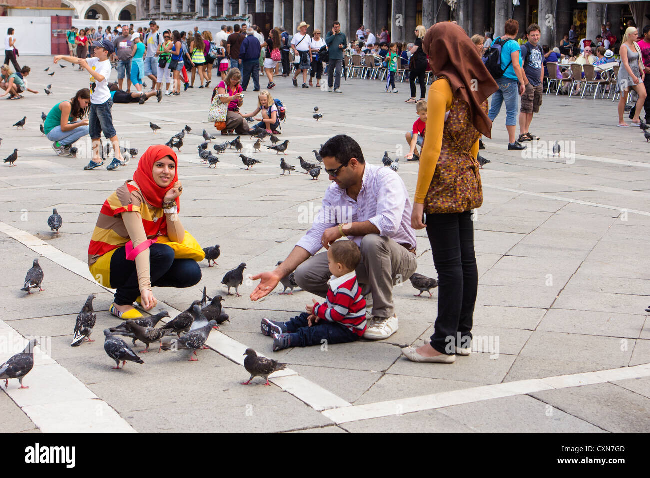 Family feeding pigeons in St Marks square Venice Italy Stock Photo