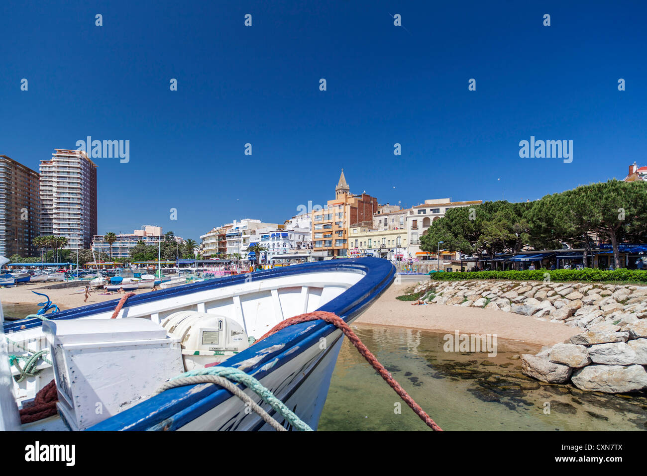 palamos,catalonia,spain.boat with village at background. Stock Photo