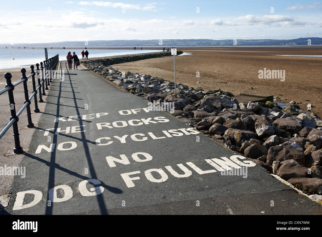 River Dee estuary with Marine Lake with painted warning signs on footpath in West Kirby  Wirral UK Stock Photo