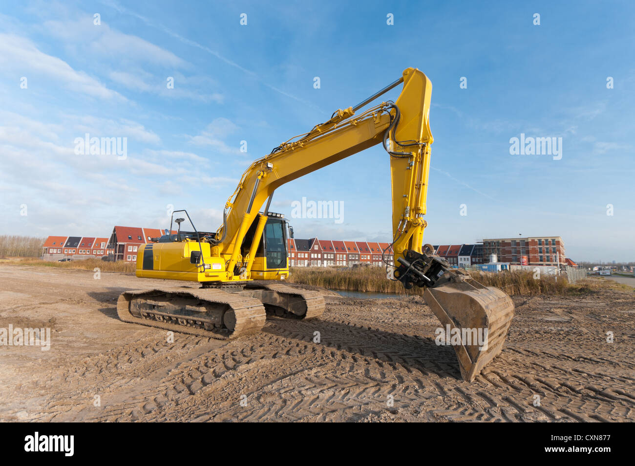 excavator in front of a newly build residential area Stock Photo