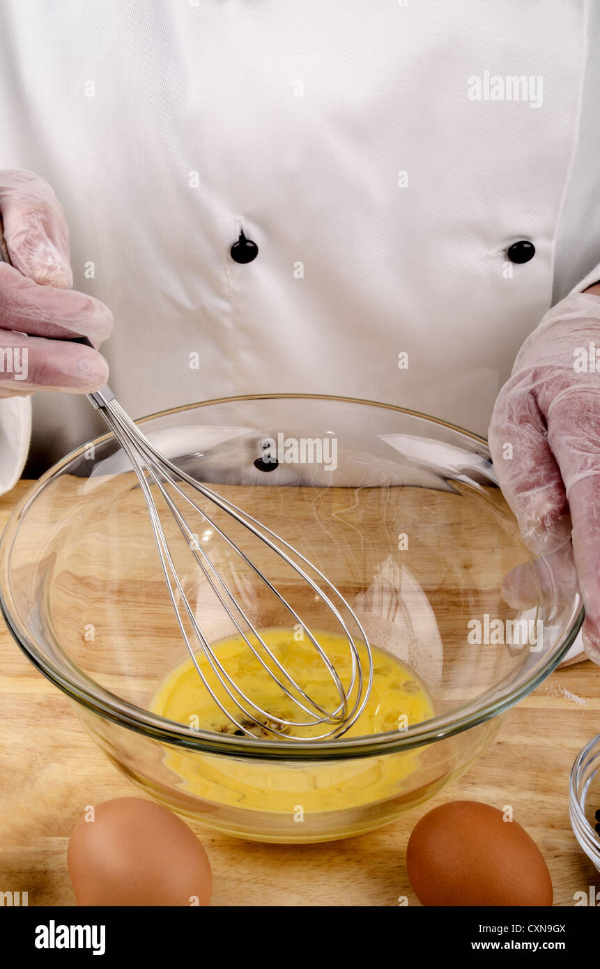 female chef stirring an egg, oil and vinegar to make mayonnaise Stock