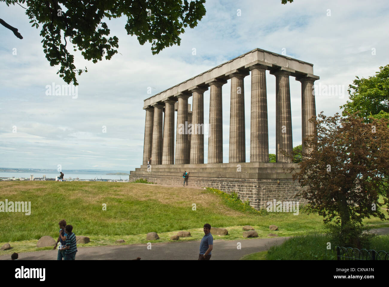 The National Monument, Calton Hill, Edinburgh. Modelled on the Parthenon. Doric columns brightly lit against cloudy skies. Stock Photo