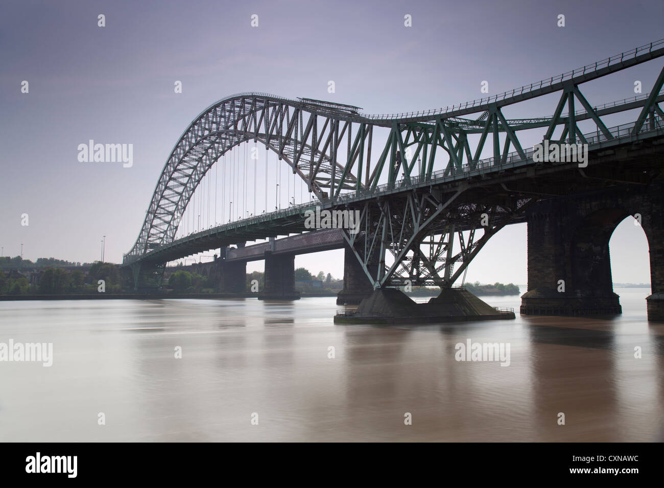 Long exposure day time image of the Runcorn Widnes bridge which spans the river Mersey and Manchester ship canal. Stock Photo