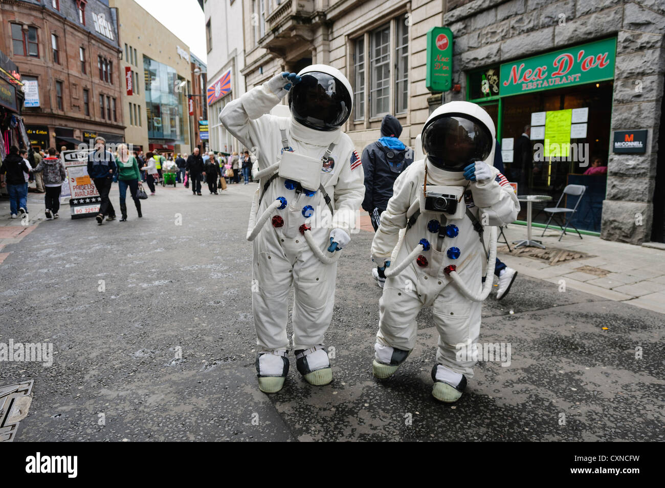 Two people dressed in Astronaut costumes 'moonwalk' around the streets of Belfast Stock Photo