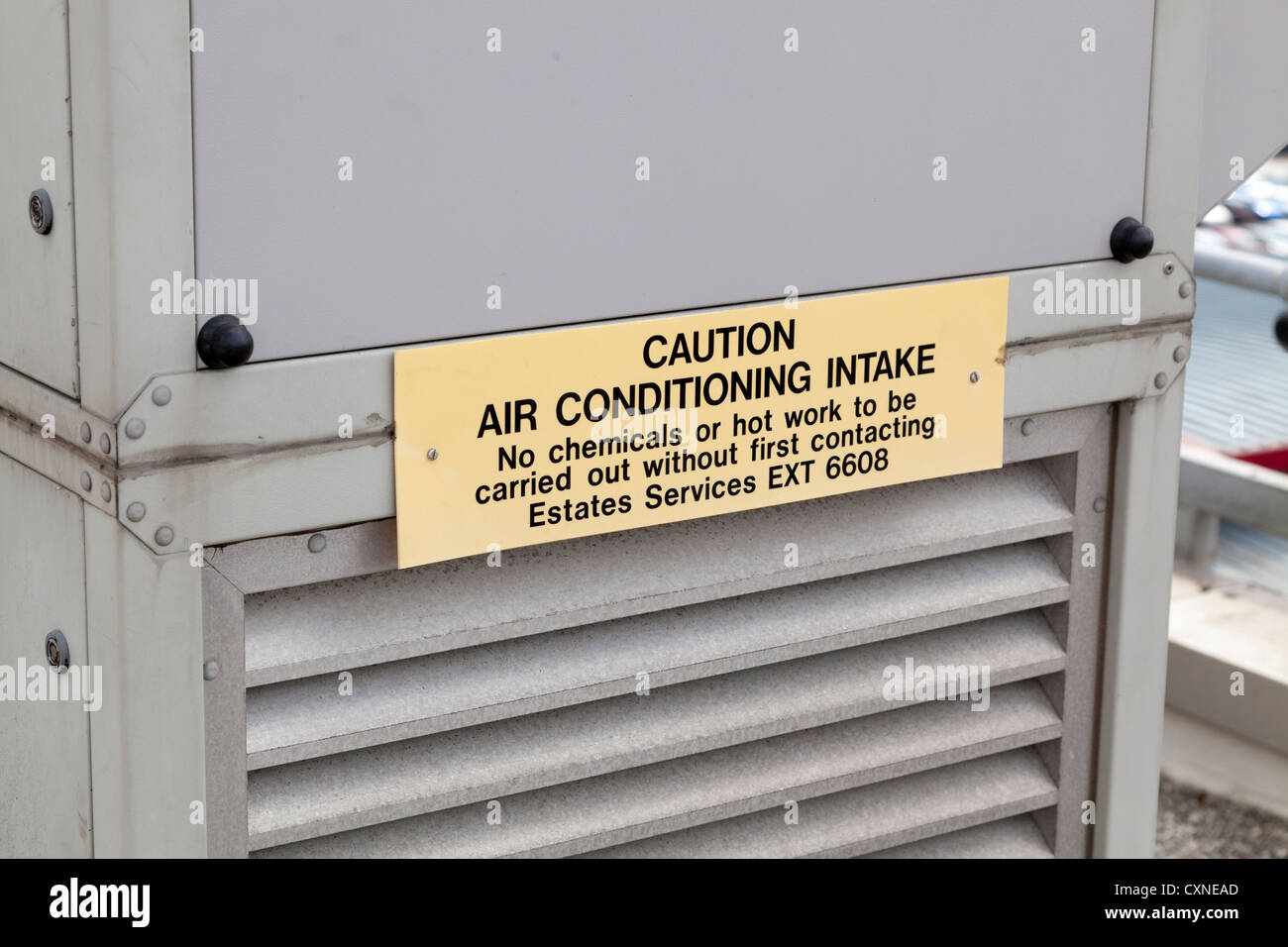 warning sign 'caution air conditioning intake' on industrial plant on