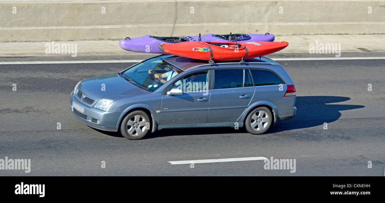 Car driving along motorway with canoe kayaks on roof Stock Photo