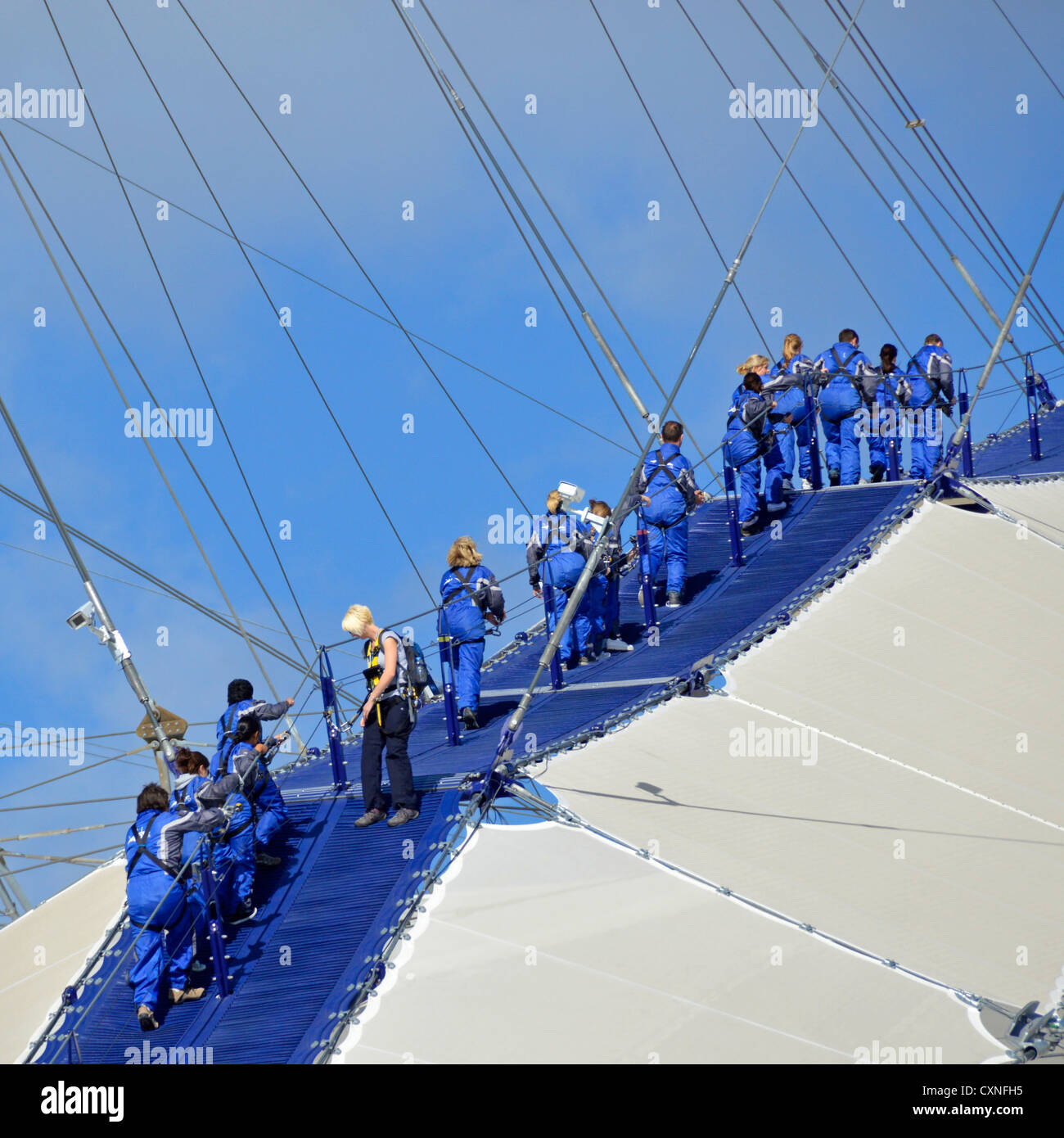 Up At The O2, people kitted out in blue overalls walking on roof of the o2 arena, sometimes referred to as the Skywalk Stock Photo