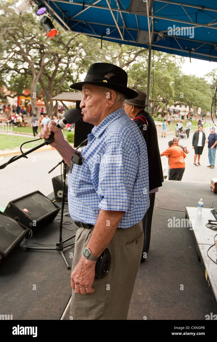 Mexican-American senior sings with a Tejano style music group at a church festival in Austin, Texas Stock Photo