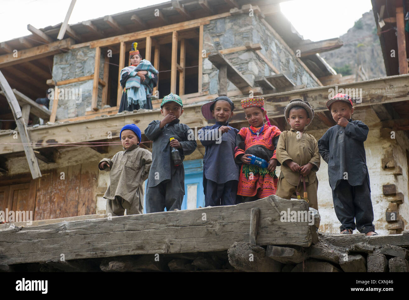 Kalash children in traditional dress on the roof of a Kalash house at Krakl Village, Bumburet Valley, Chitral, Khyber-Pakhtunkhwa, Pakistan Stock Photo