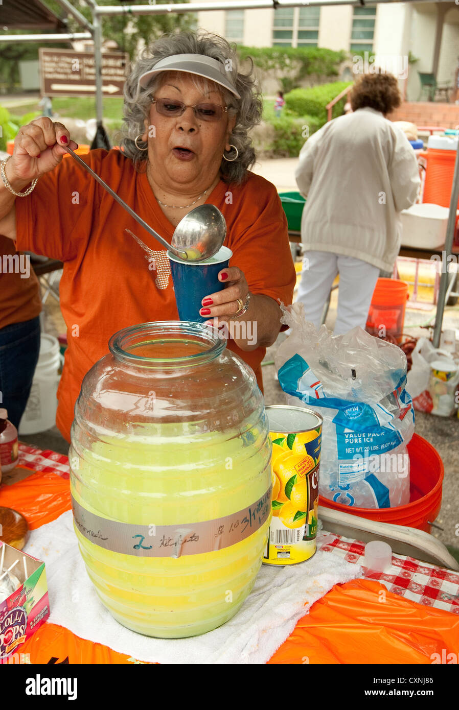 Hispanic woman fills plastic cup with lemonade at church festival in Austin, Texas Stock Photo