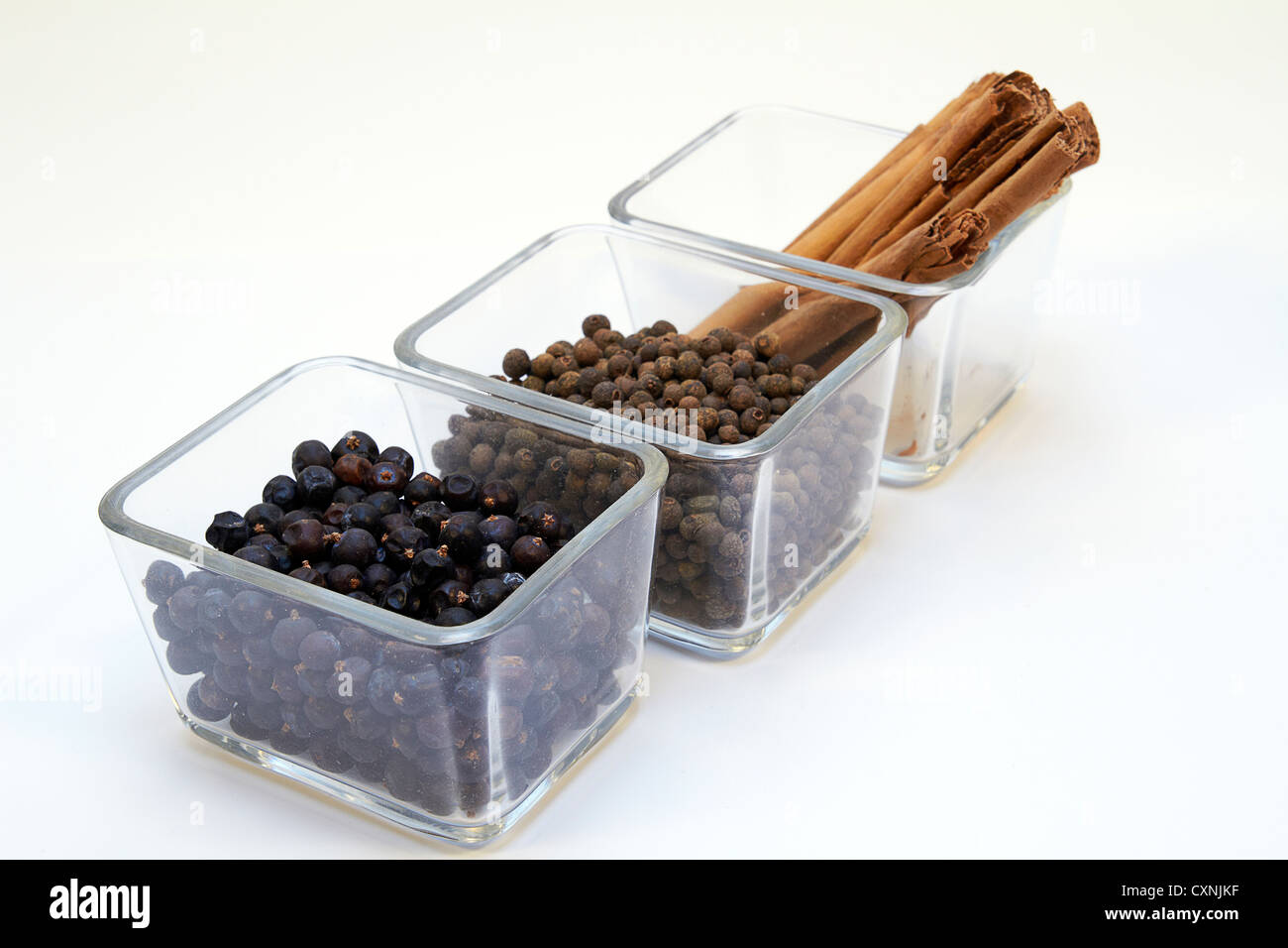 cinnamon, allspice grains / pimento and Juniper berries in a glass bowl