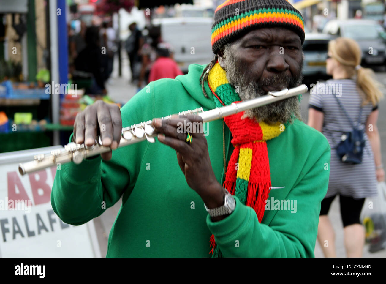African flute player on street Caucasian girl walking behind Stock Photo Alamy
