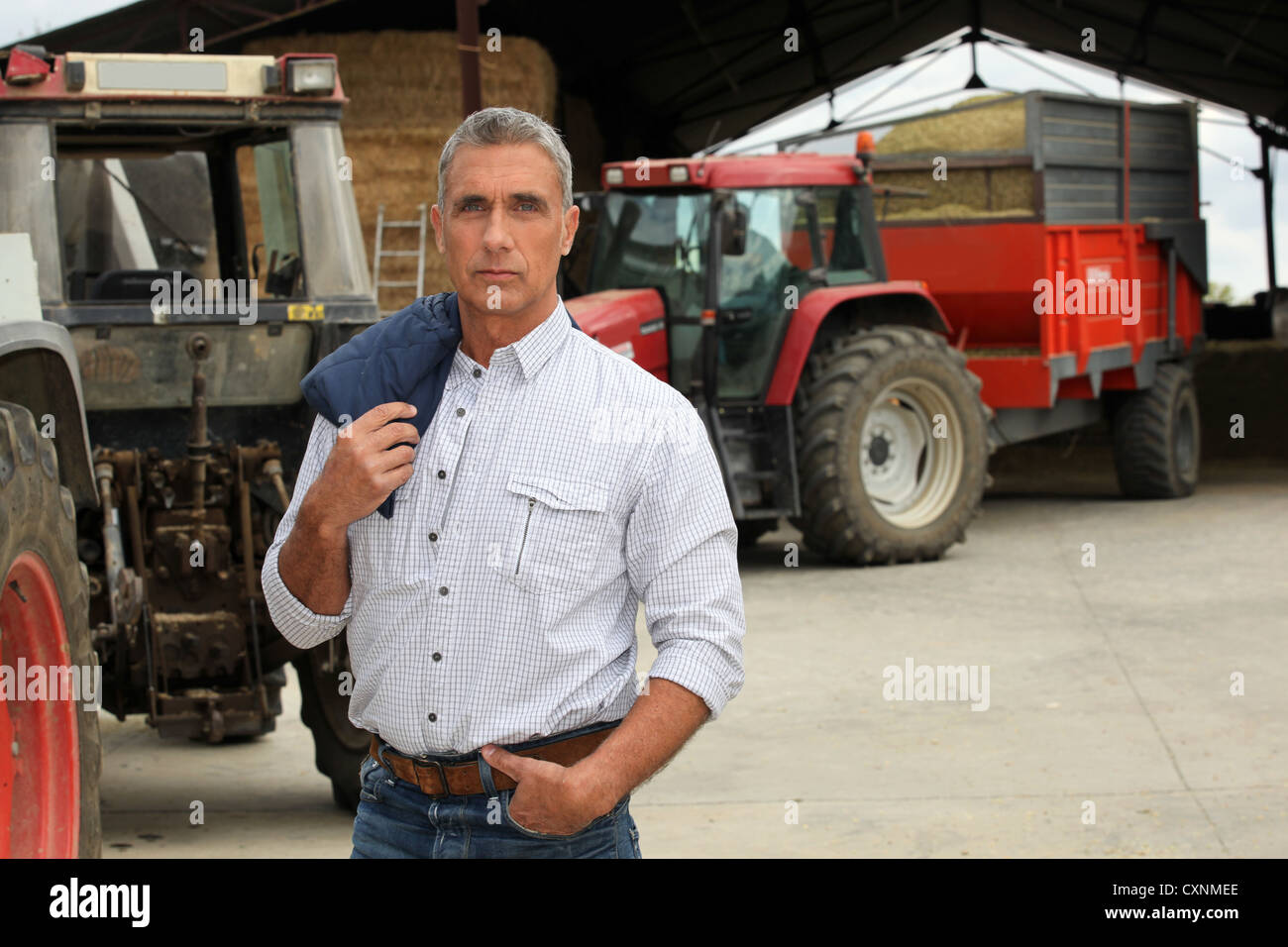 Farmer stood in front of tractors Stock Photo - Alamy