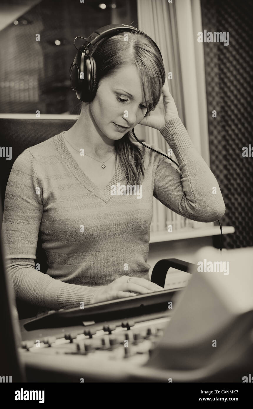 Portrait of female dj working in front of a microphone on the radio Stock Photo