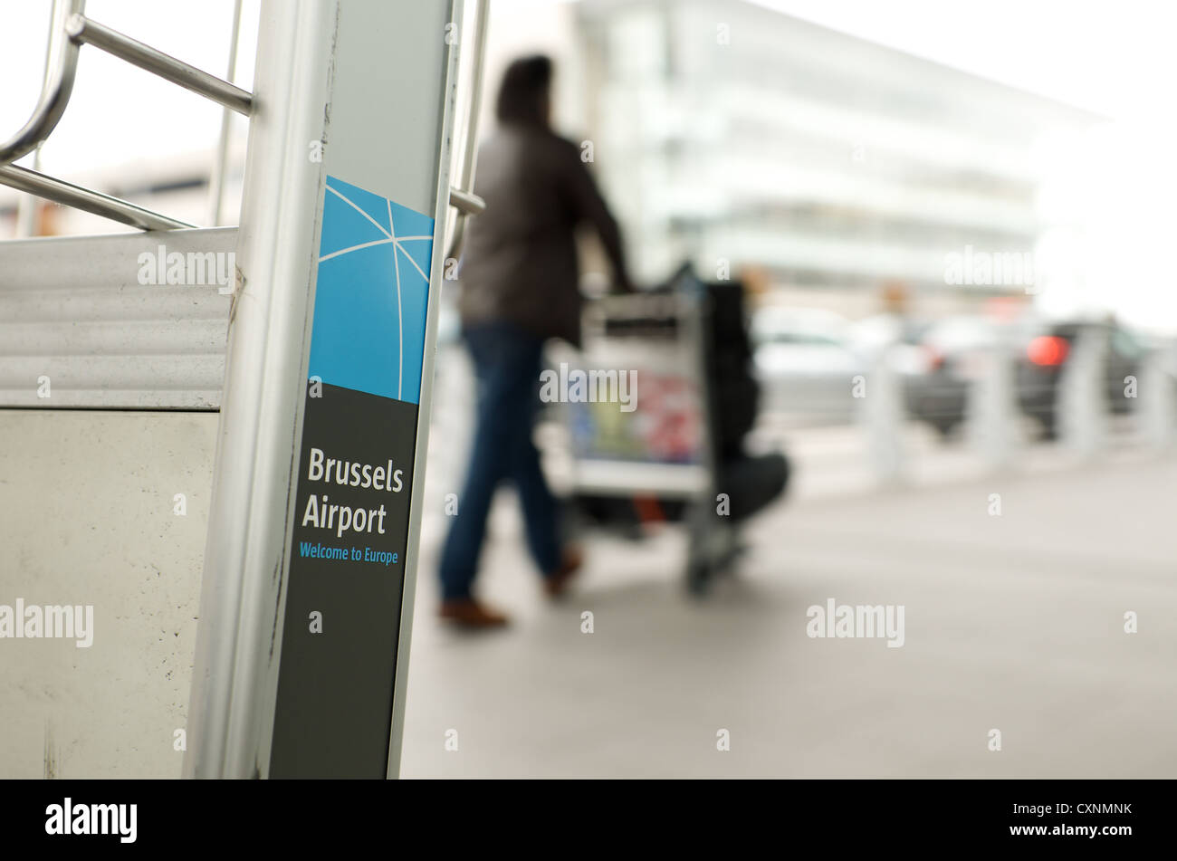 Brussels airport baggage trolley with logo of airport. In background is