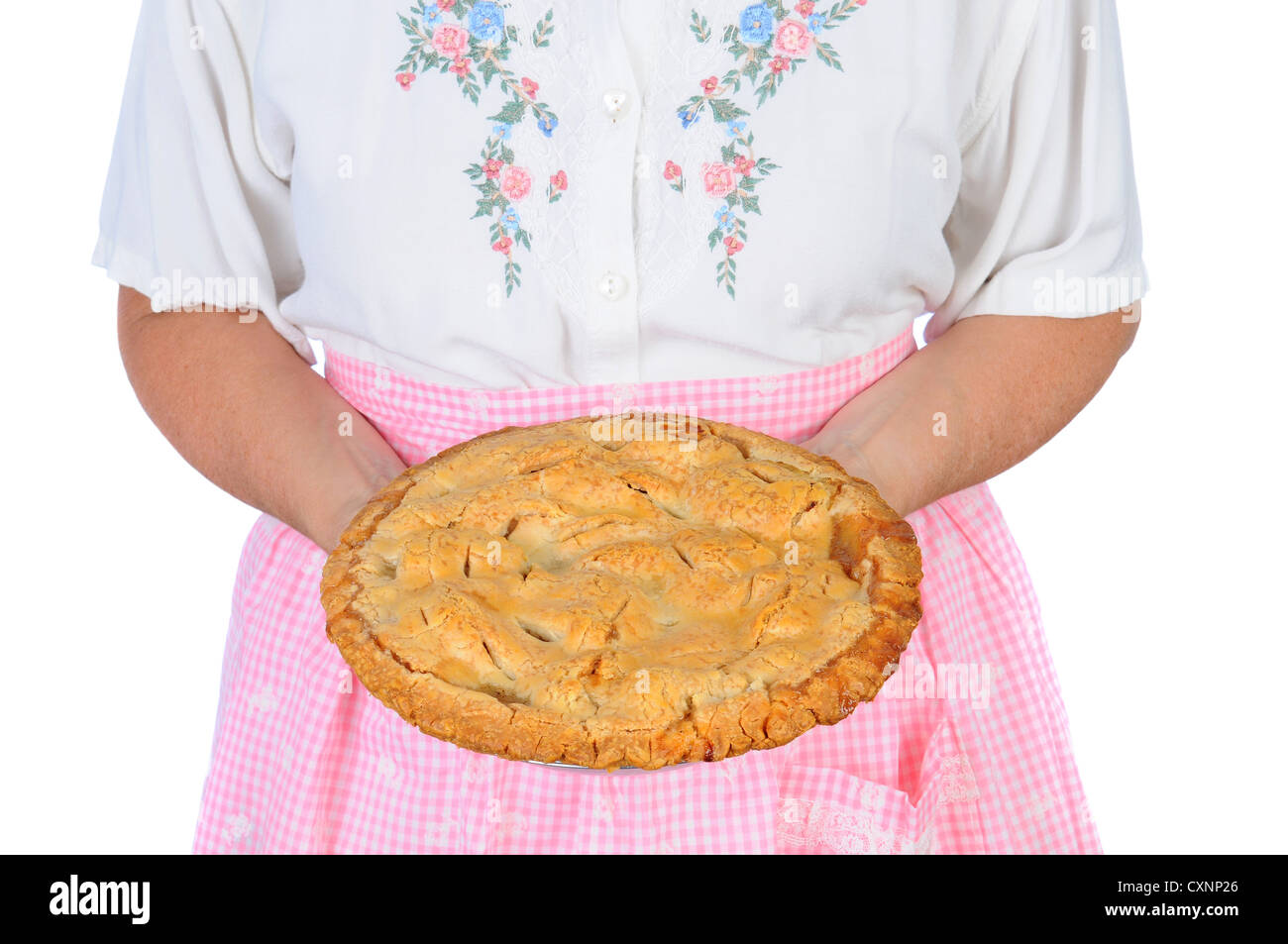 Closeup of a woman holding a freshly baked apple pie in fron of her
