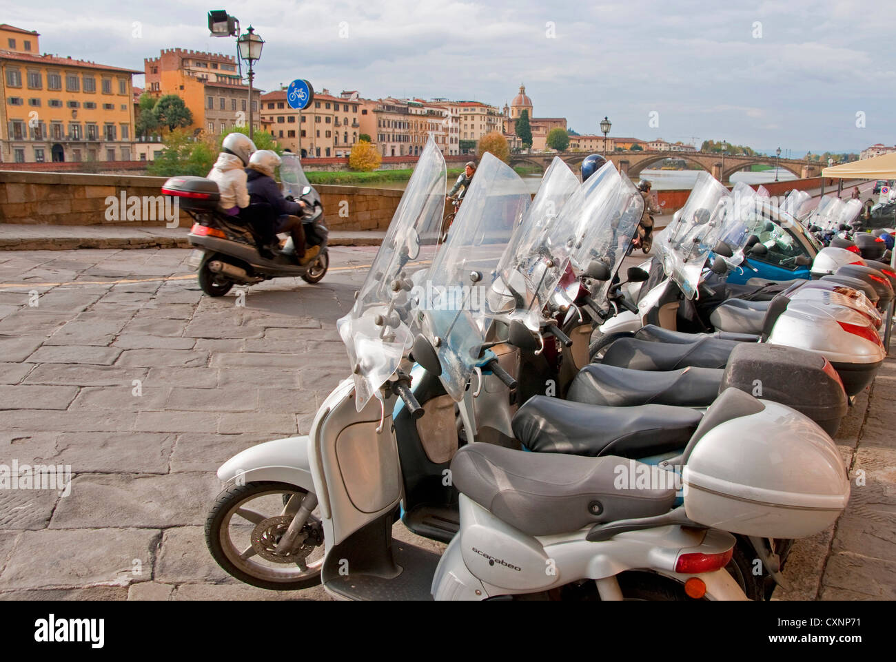 Florence motor scooters along Arno River Stock Photo